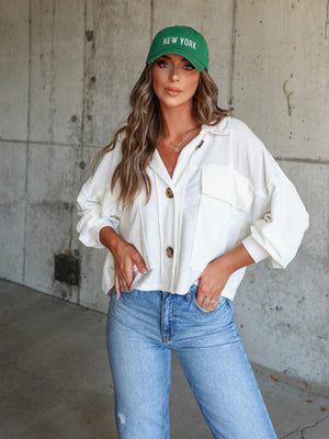 White textured boxy utility shirt jacket with button front and chest pockets.