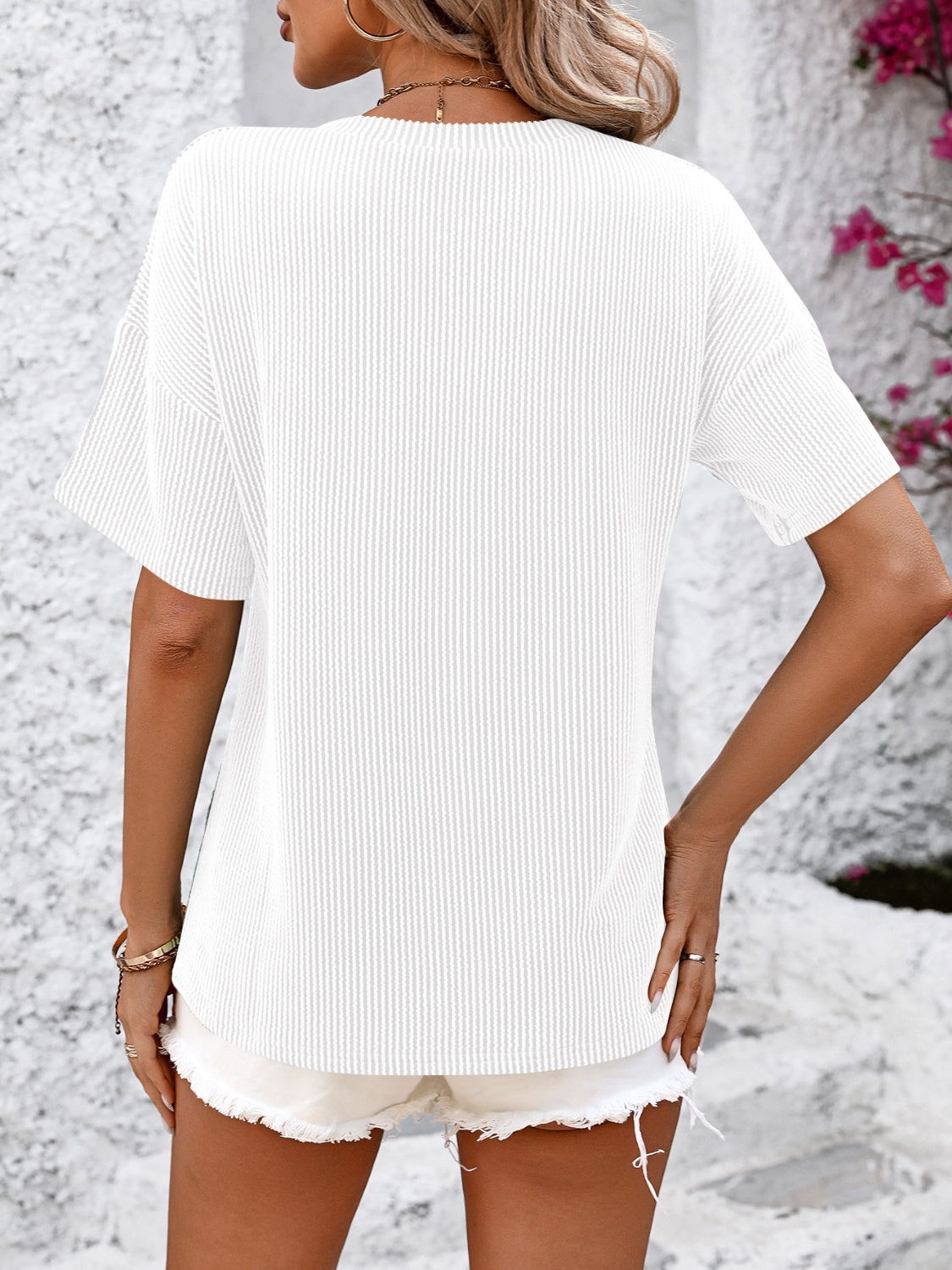 White ribbed V-neck t-shirt with short sleeves and a pocket detail.