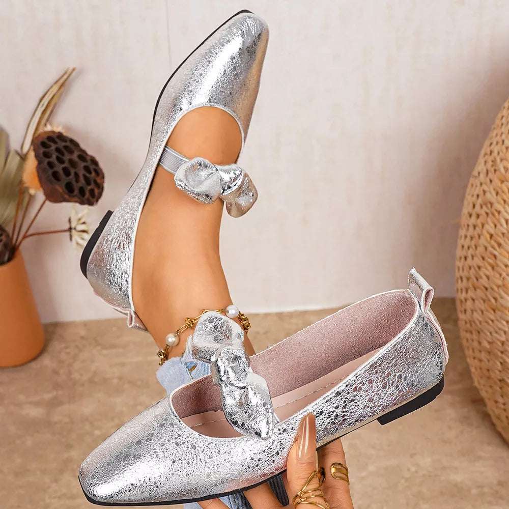 Chic silver slip-on flats with square toe and bow detail on ankle strap.