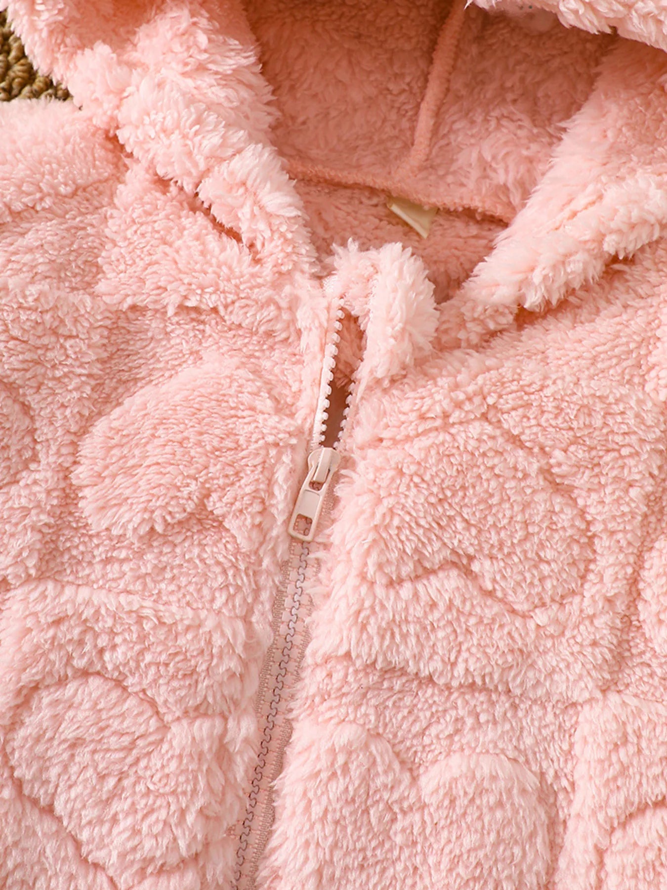 Dusty pink fuzzy hooded jacket with heart pattern and zipper detail.