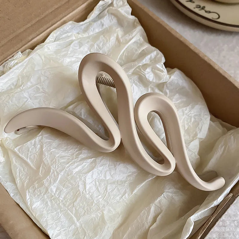 Sculptural hair claw in Dust Storm acrylic with serpentine design