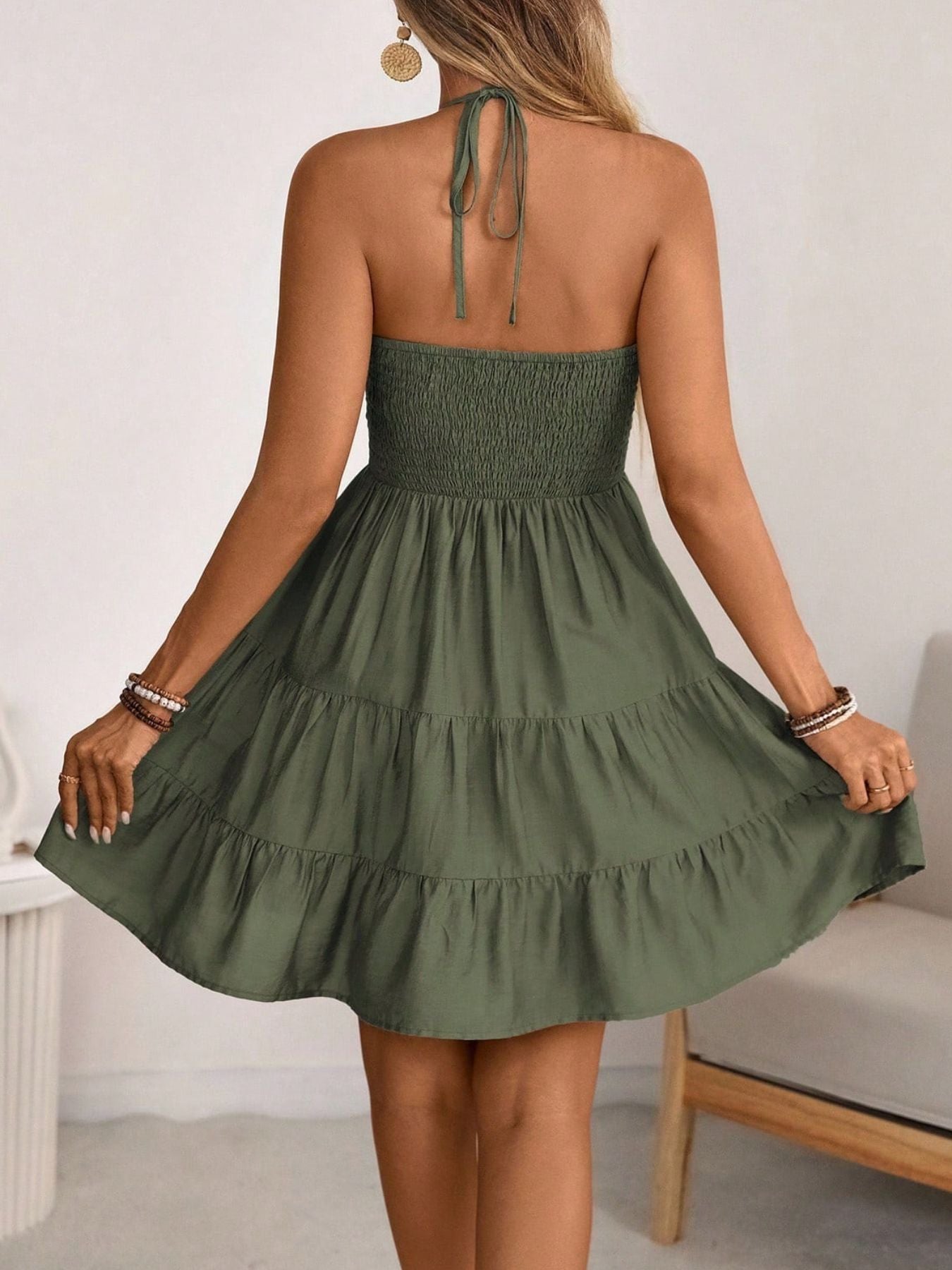 Olive green ruched halter tiered mini dress with ruffled hem.