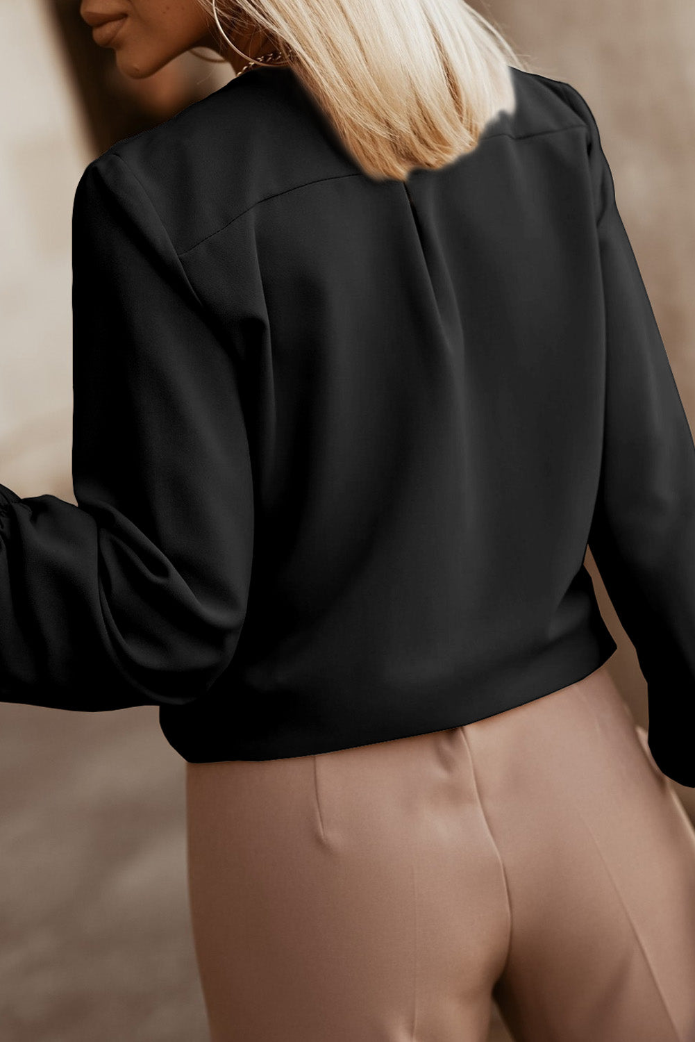 Black pleated yoke blouse with button detail and long sleeves.