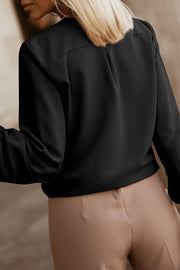 Black pleated yoke blouse with button detail and long sleeves.