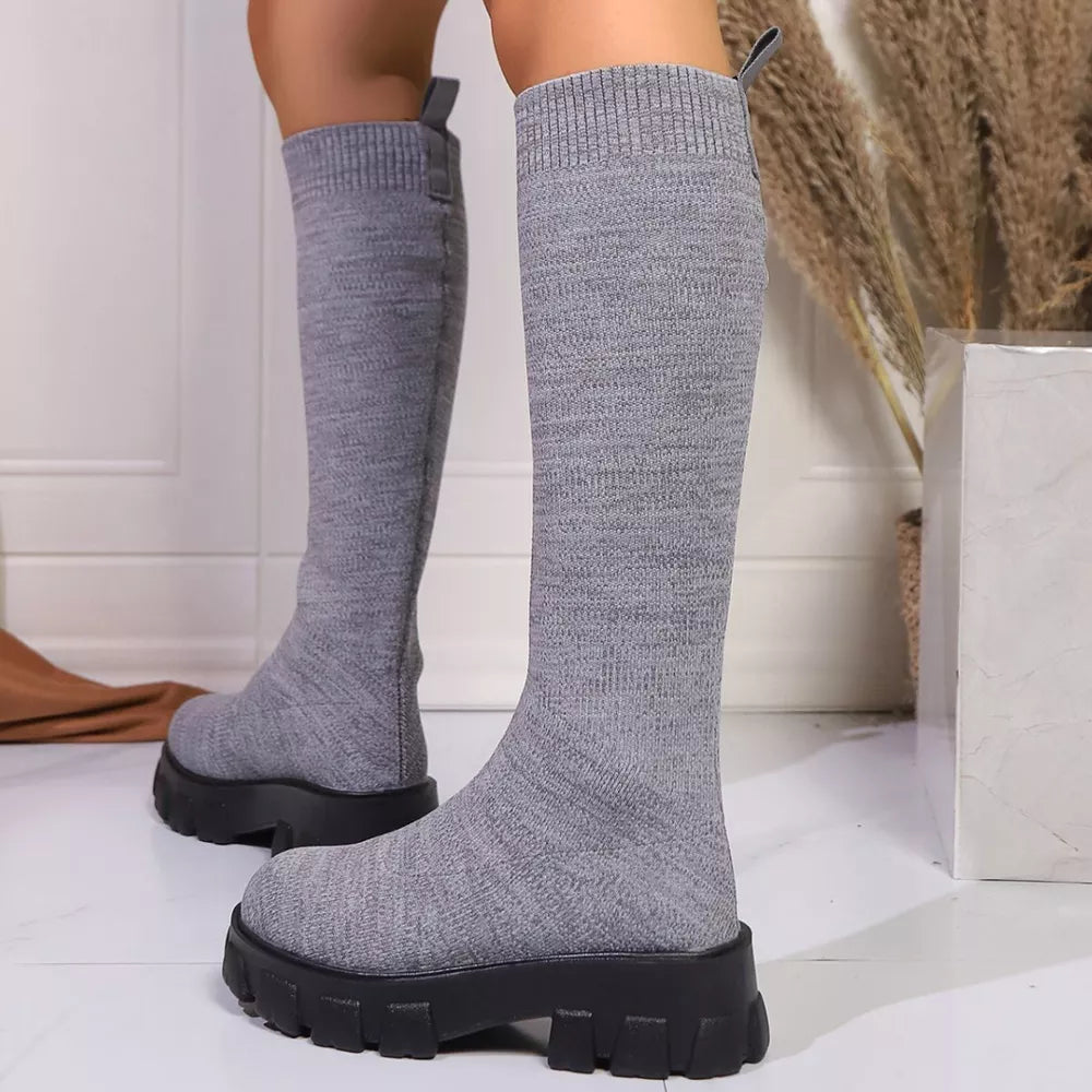 Gray knit knee-high boots with chunky platform soles and pull tabs.