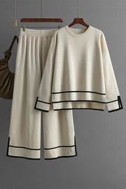 Cream acrylic loungewear set with round neck top and wide leg pants, featuring black trim details.