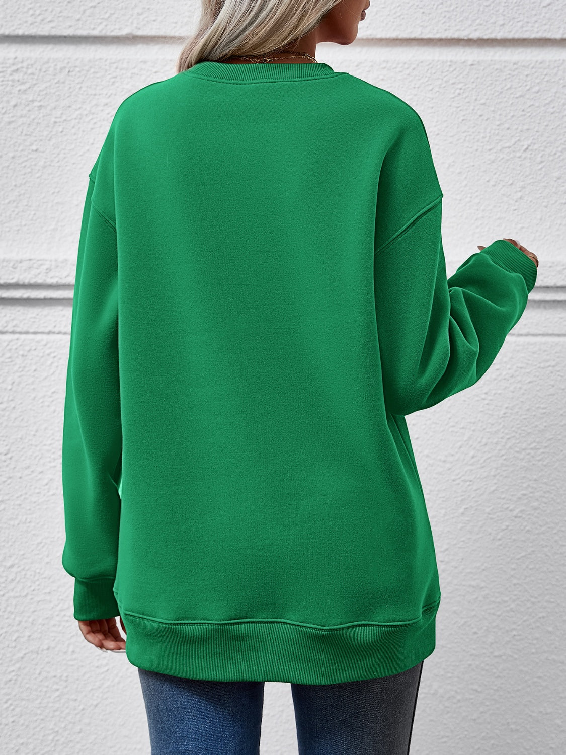 Green crewneck sweatshirt with long sleeves and ribbed cuffs and hem.