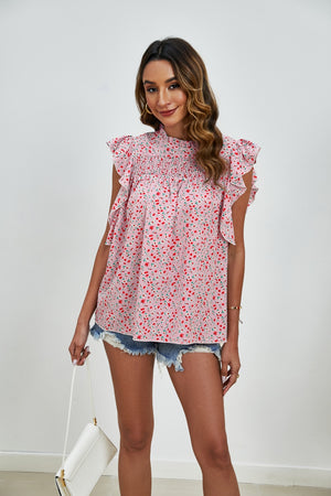 Blush pink floral blouse with smocked yoke and ruffle sleeves.