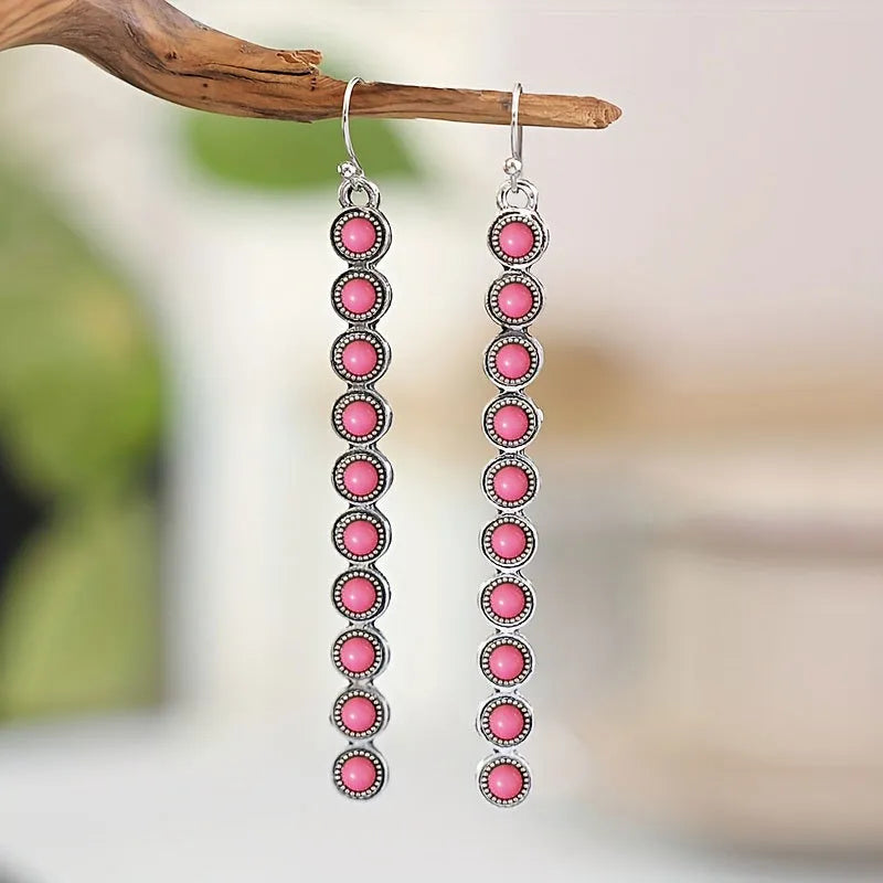 Linear drop earrings with pink artificial turquoise stones and silver-tone alloy settings.