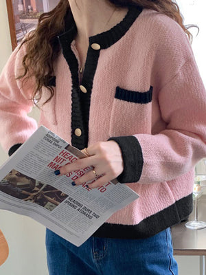 Pink acrylic button up cardigan with contrast black trim and pockets
