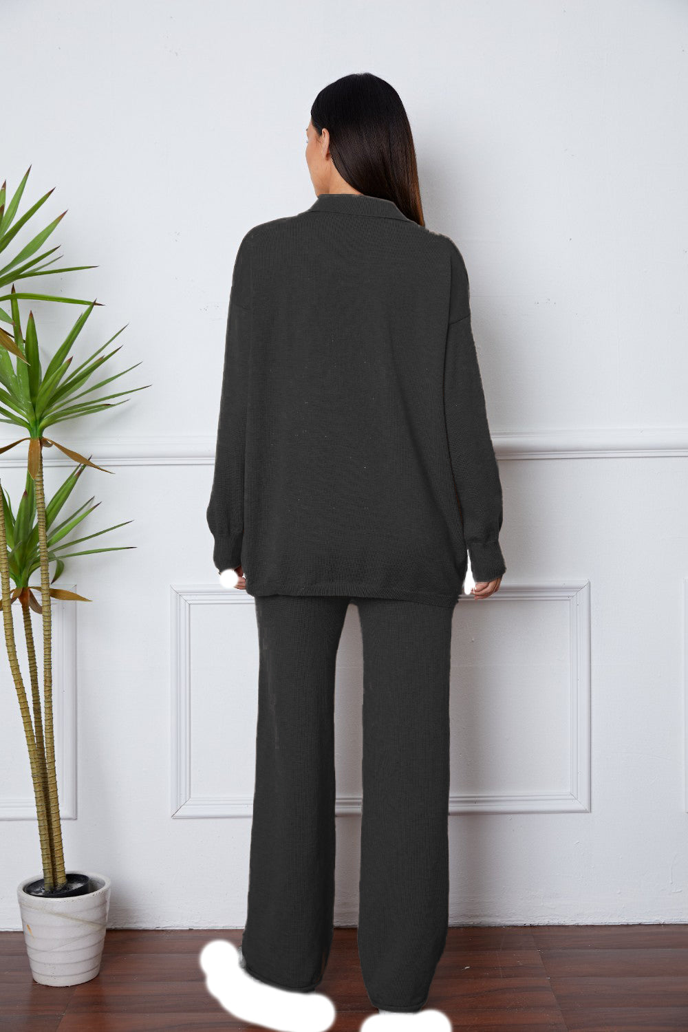 Black relaxed knit polo co-ord set with wide leg pants and long sleeves.