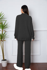 Black relaxed knit polo co-ord set with wide leg pants and long sleeves.