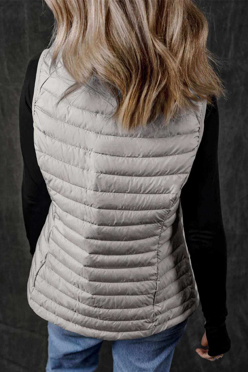 Gray quilted puffer vest with horizontal quilting and fleece collar detail.