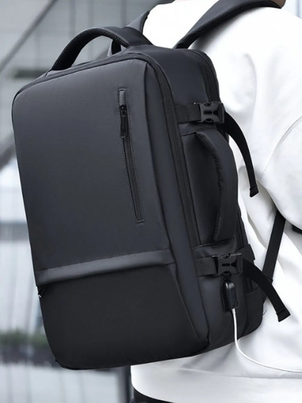 Black convertible commuter backpack with USB port and zippered front pocket.