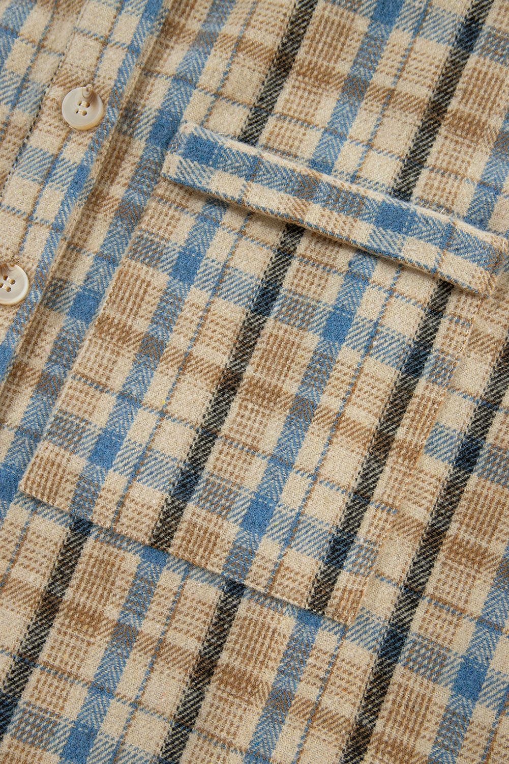 Textured plaid hooded overshirt with raw hem, featuring a beige, blue, and black plaid pattern and button closure.