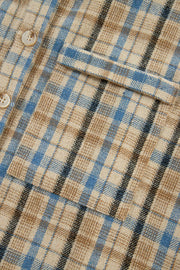 Textured plaid hooded overshirt with raw hem, featuring a beige, blue, and black plaid pattern and button closure.