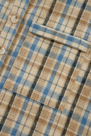 Textured plaid hooded overshirt with raw hem, featuring a beige, blue, and black plaid pattern and button closure.