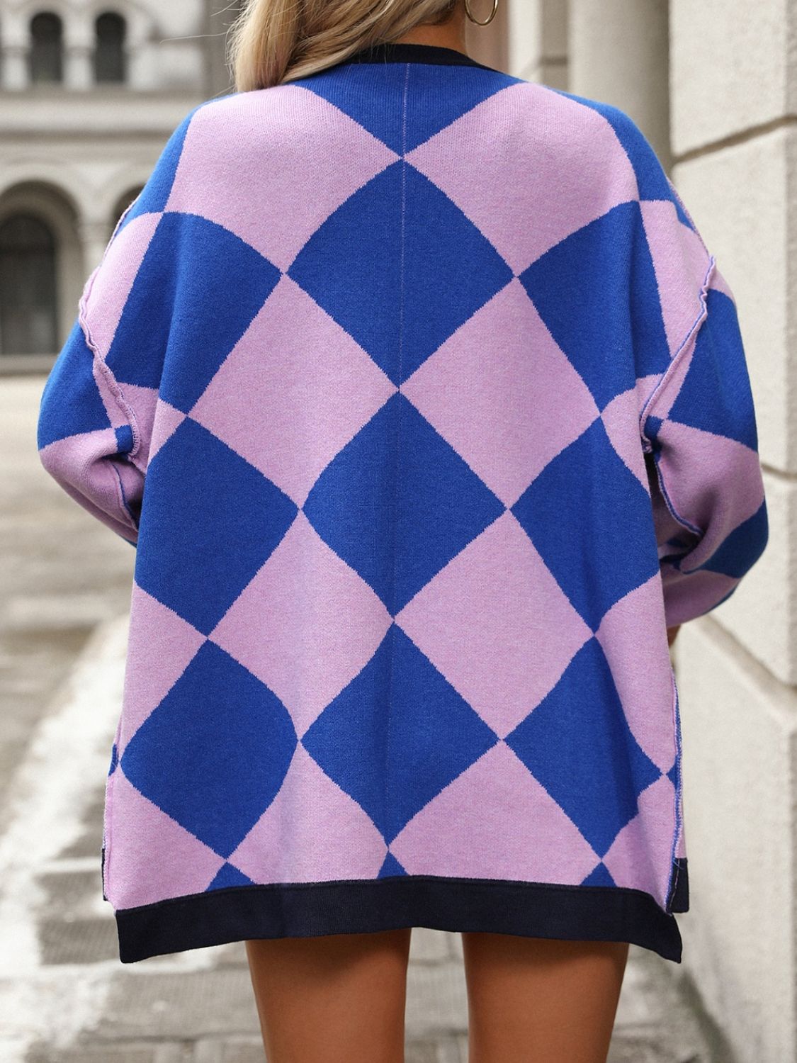 Argyle knit oversized cardigan in pink purple and blue with black trim.