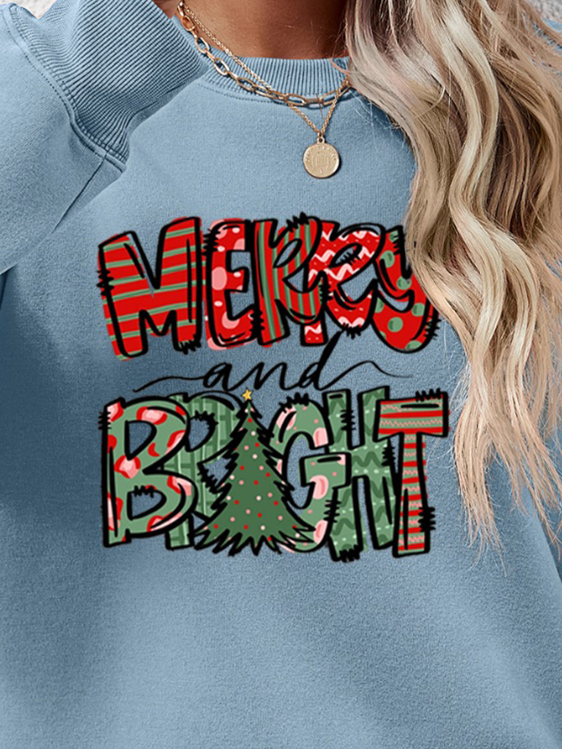 Misty Blue crewneck sweatshirt with Merry and Bright Christmas graphic and festive patterns.
