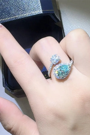 Bypass ring with turquoise pear-cut moissanite halo and diamond accents.