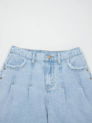 Light wash denim jeans with studded pockets and wide legs.
