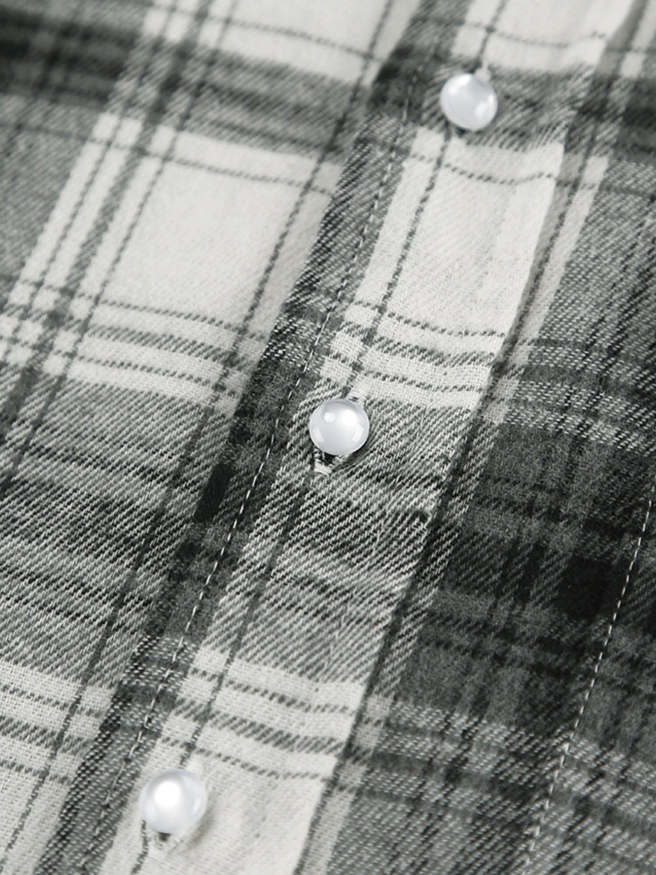 Button-up long sleeve shirt in black and white plaid cotton with pearl buttons.