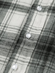 Button-up long sleeve shirt in black and white plaid cotton with pearl buttons.