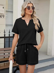 Black relaxed two-piece set with drawstring shorts and v-neck top with pockets