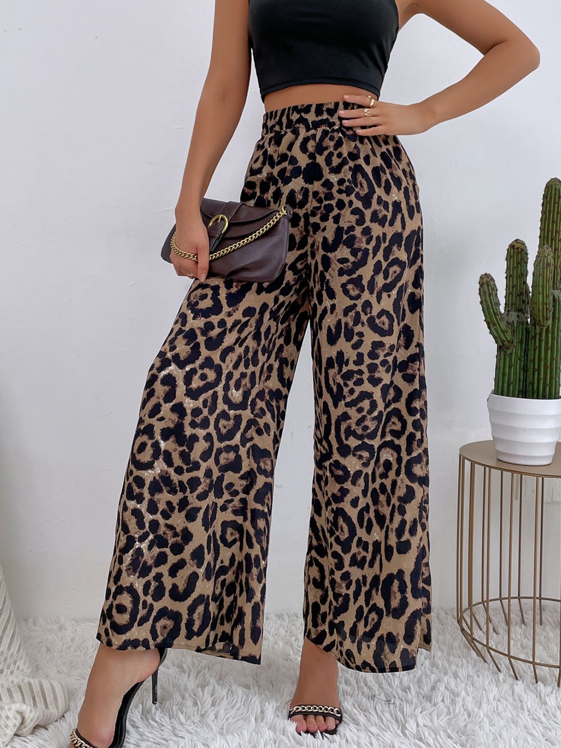 Leopard print palazzo trousers with a high waist and wide leg, styled with a black crop top and brown handbag.
