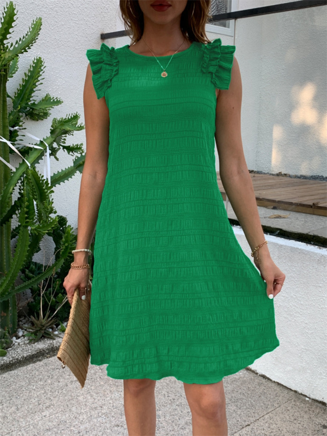 Green textured ruffle shoulder mini dress with a textured pattern.