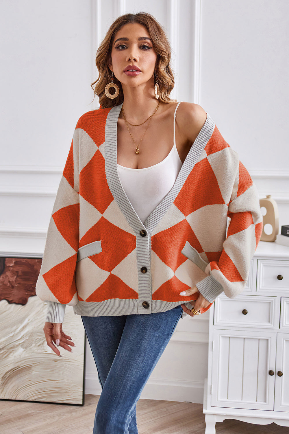 Diamond knit balloon sleeve cardigan in orange and cream with grey trim and pockets.