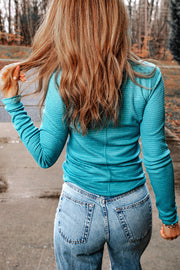 Turquoise waffle knit henley shirt with snap detail and long sleeves.