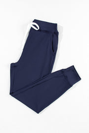 Slim-fit navy joggers with white drawstring and side pockets.