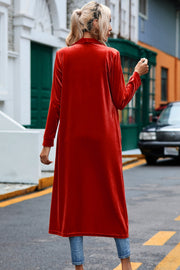 Deep Red velvet duster coat with long sleeves and open front, styled with jeans.