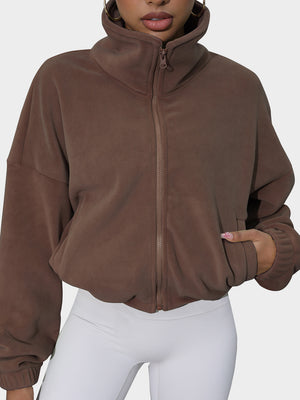 Coffee brown fleece cropped jacket with funnel neck and zip front, styled with white leggings.
