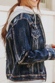 Dark blue denim jacket with grey hooded layer, zip front, and distressed details.