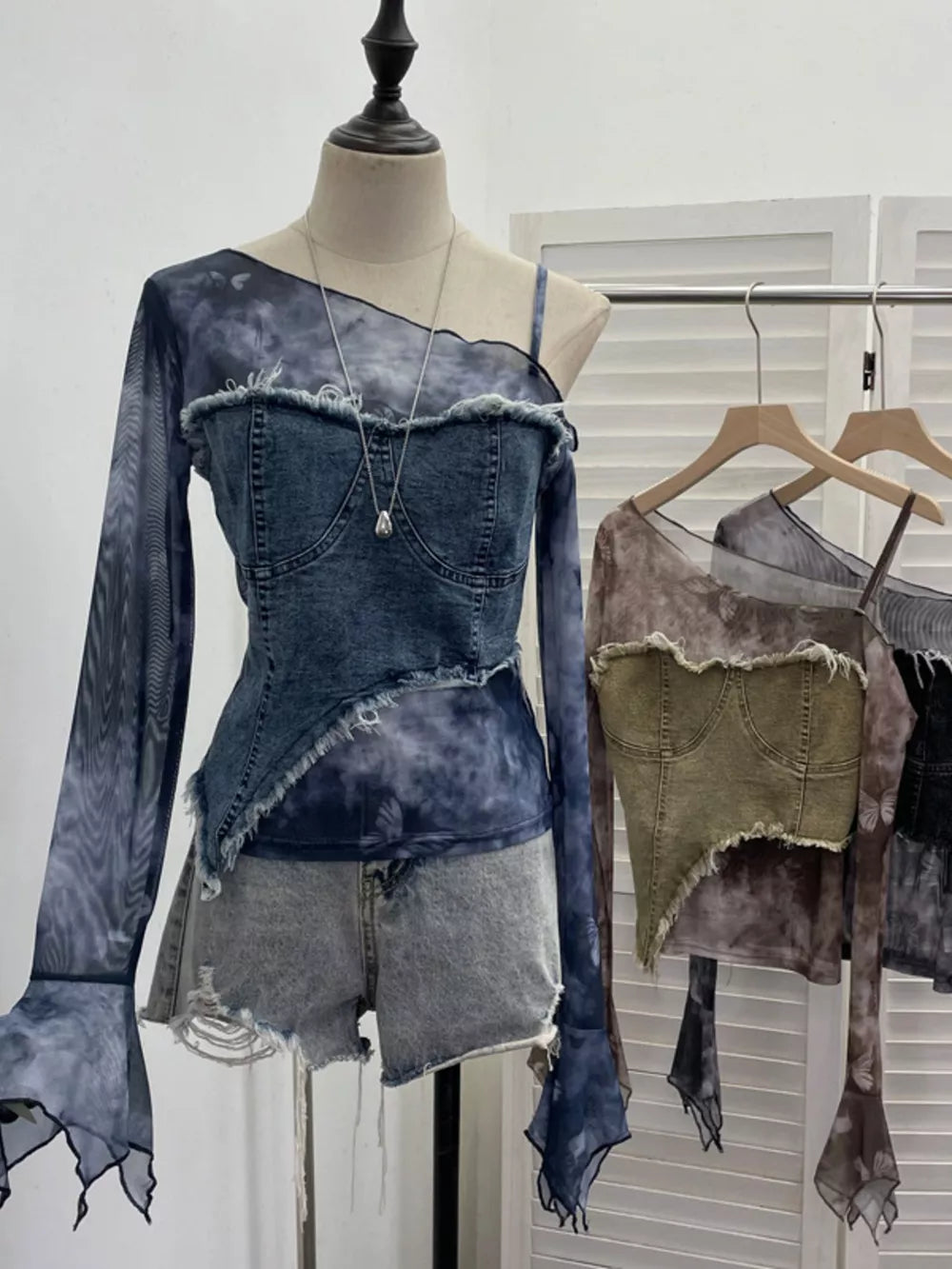 Edgy asymmetrical denim layered t-shirt in gray black with tie-dye mesh sleeves and frayed hem.