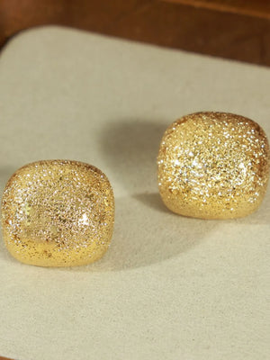 Textured gold cube earrings with glitter detail.