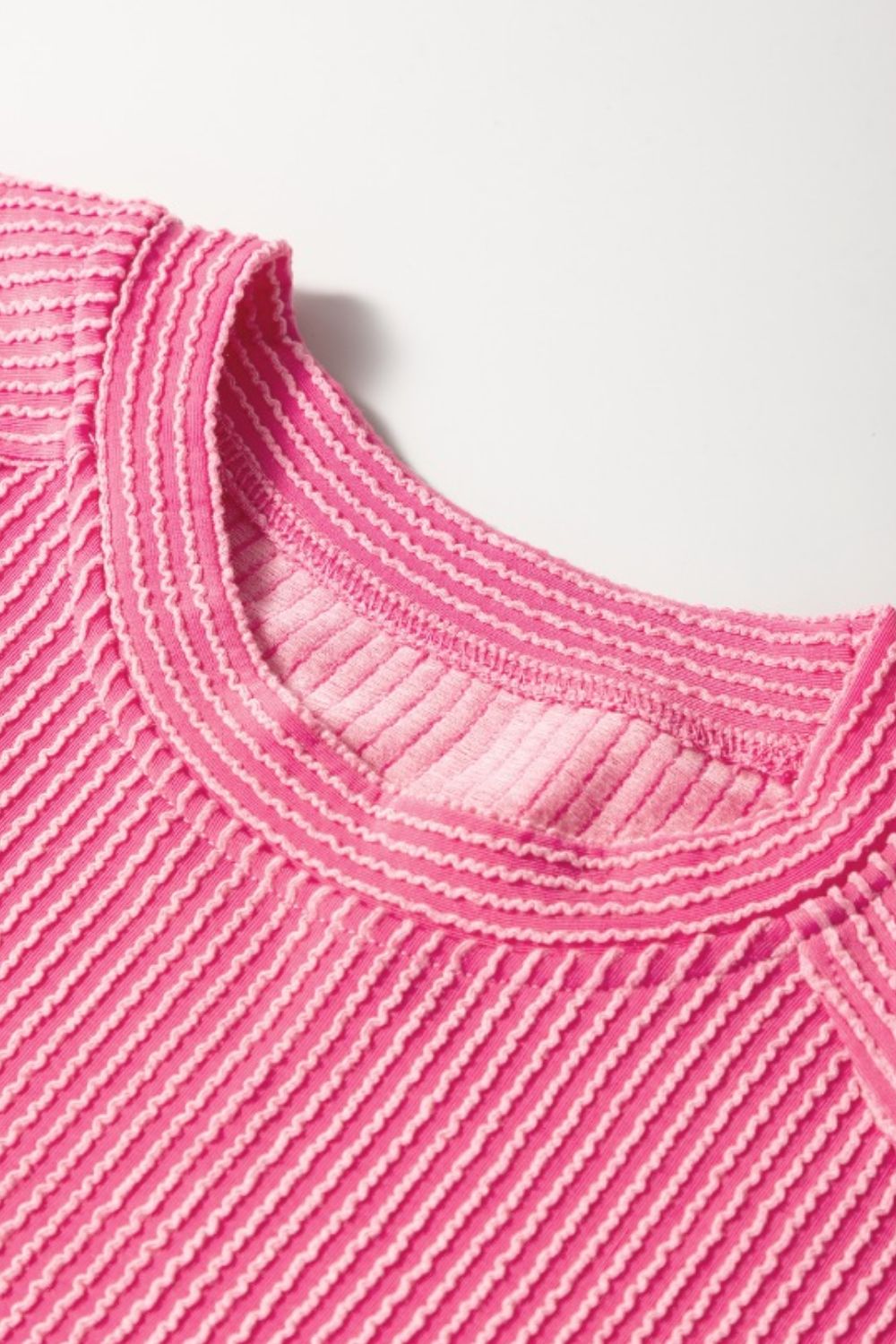 Fuchsia pink ribbed knit co-ord set top with textured stripes and contrast stitching at the neckline.