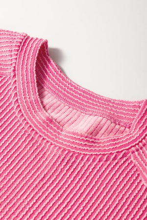 Fuchsia pink ribbed knit co-ord set top with textured stripes and contrast stitching at the neckline.