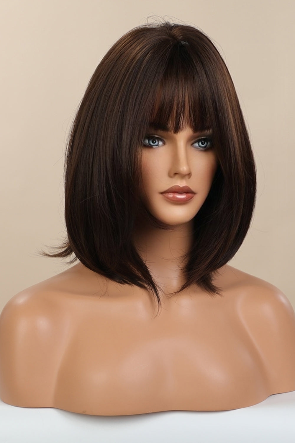 Black/Brown bob wig with wispy bangs on a mannequin.