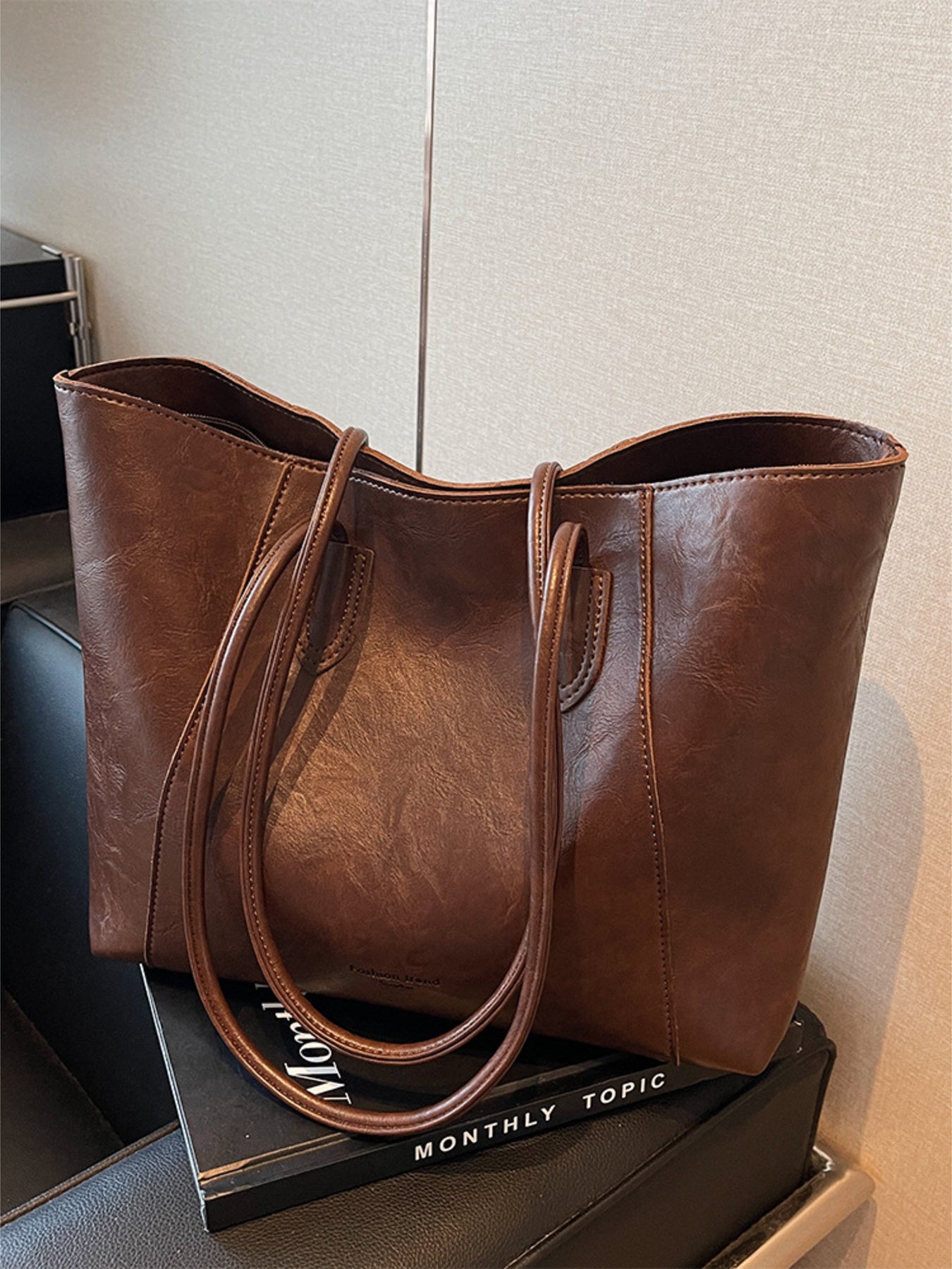 Brown crinkled PU leather tote bag with double straps and a spacious interior.