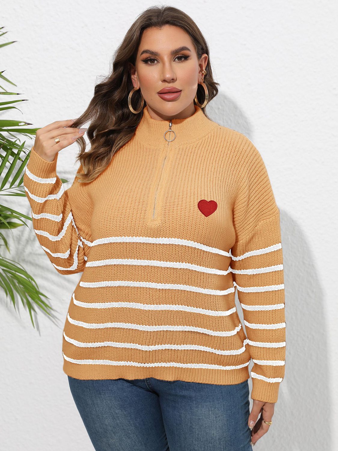 Tangerine ribbed knit sweater with white stripes, mock neck, quarter zip, and red heart appliqué.
