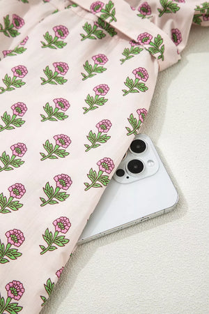 Blush pink floral midi dress with button front and scalloped trim detail.