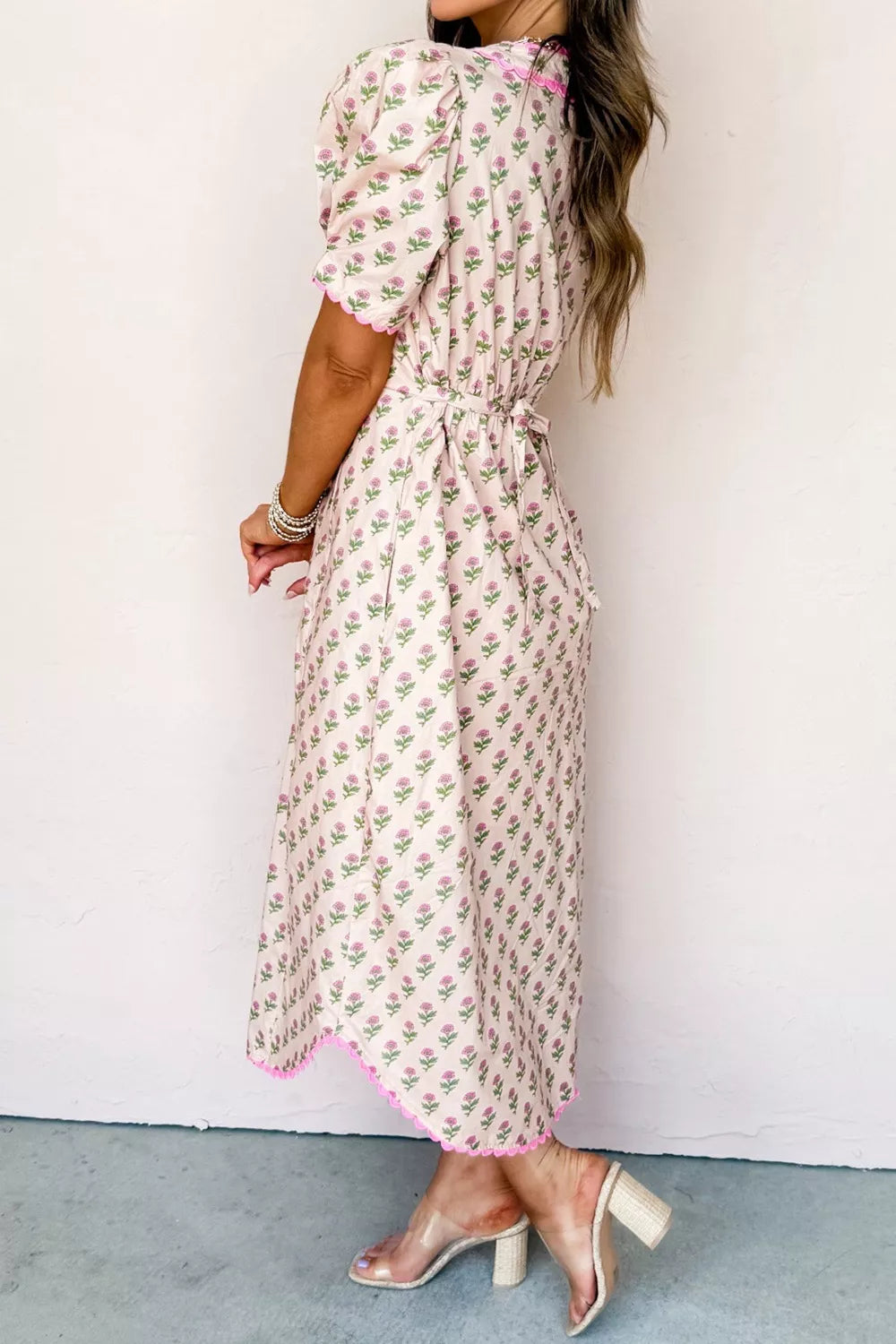 Blush pink floral midi dress with short puff sleeves, tie waist, and scalloped trim.