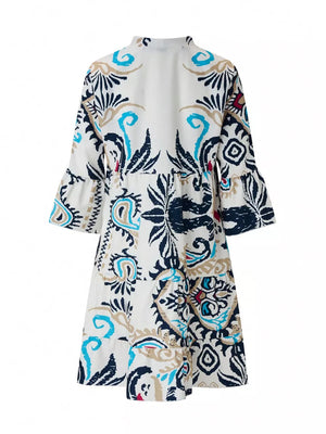 Vibrant tiered mini dress with abstract print, collared neckline, button detail, and ruffled sleeves.