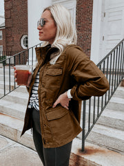 Brown utility jacket with four front pockets and a zip-up closure.