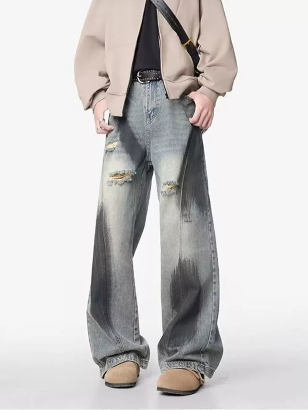 Distressed wide-leg jeans with belt detail, featuring a faded wash and ripped accents.