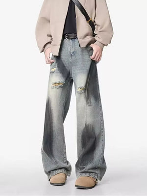 Distressed wide-leg jeans with belt detail, featuring a faded wash and ripped accents.