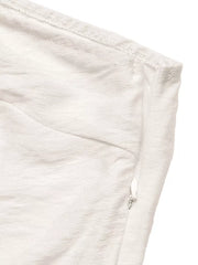 Cream one-shoulder top detail with side zipper and textured fabric.
